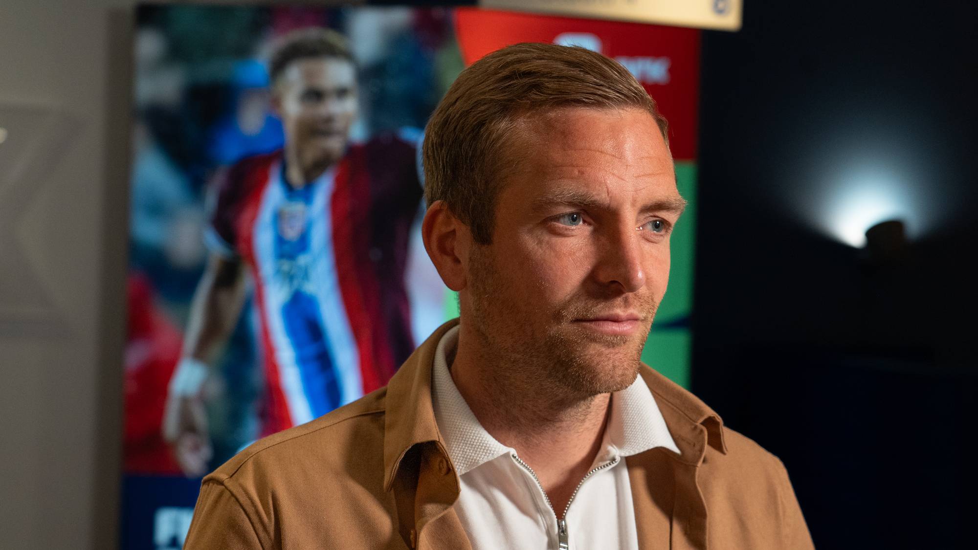 Kristoffer Lie Løkberg med en VM-plakat i bakgrunnen
