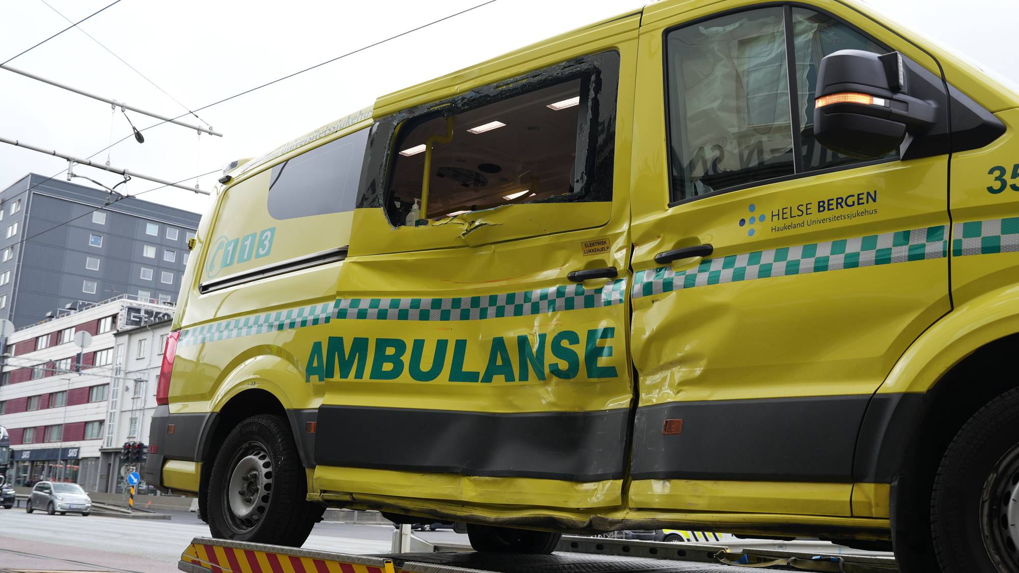 en ambulanse på en bergensbil med skader i sida