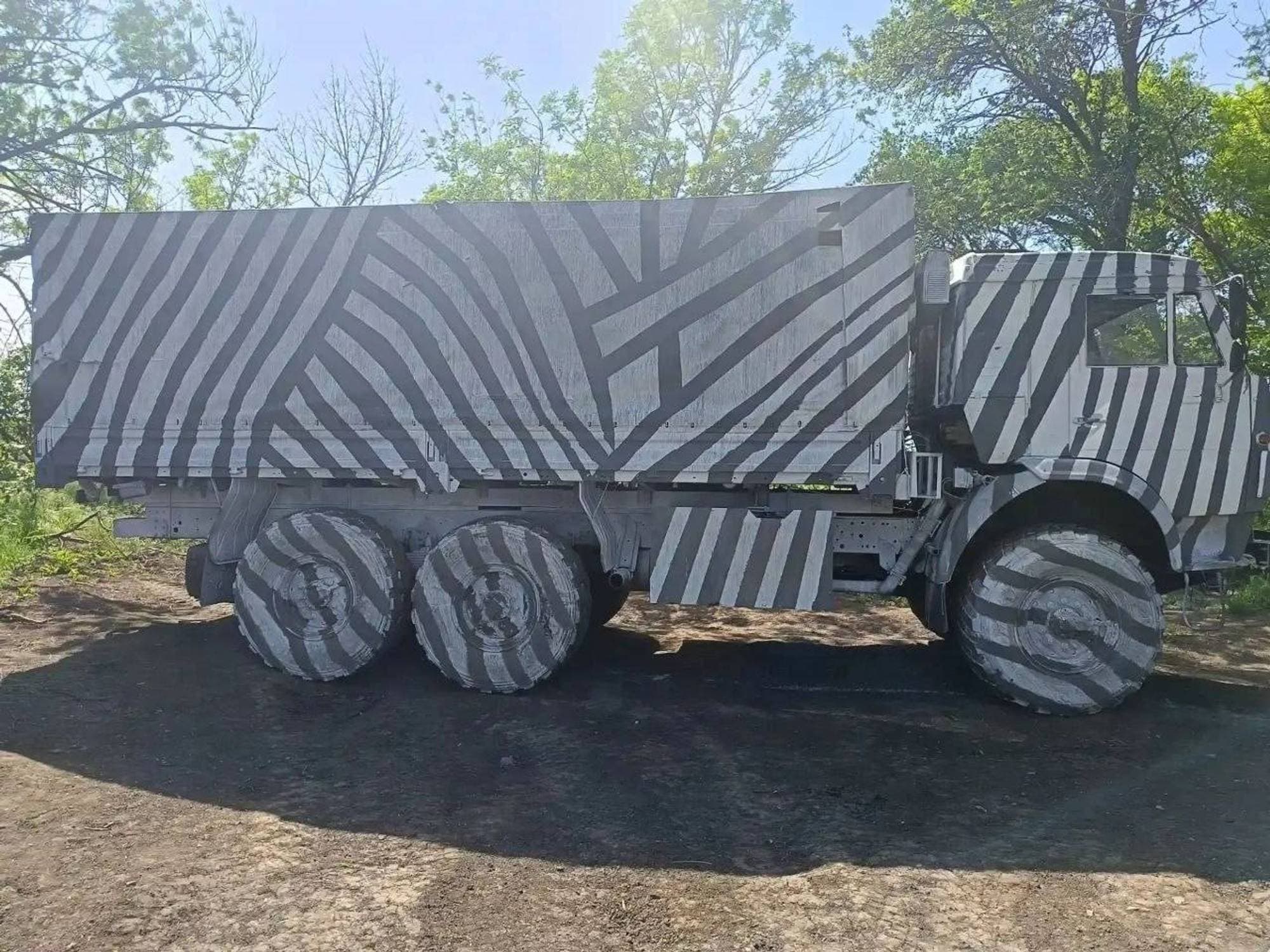 Bilder av russiske militære kjøretøyer malt med sorte og hvite striper.