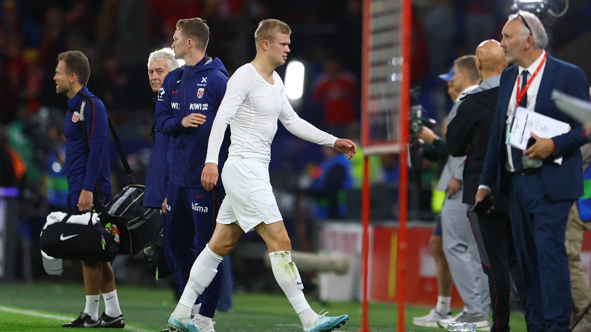 Erling Braut Haaland går av banen sammen med støtteapparat på Ullevaal stadion. (Bildebeskrivelsen er laget av en KI-tjeneste)