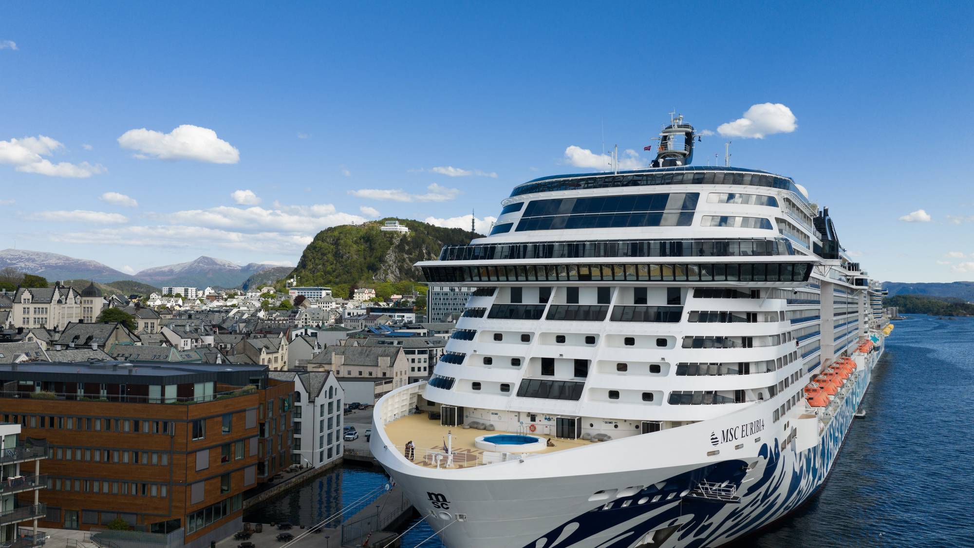 eit svært turistskip framfor byen