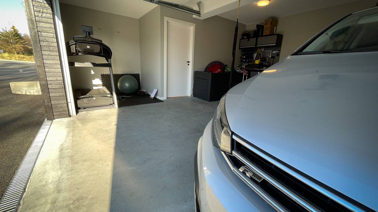 Tredemølle og bil deler plass i denne garasjen i Spjelkavika.