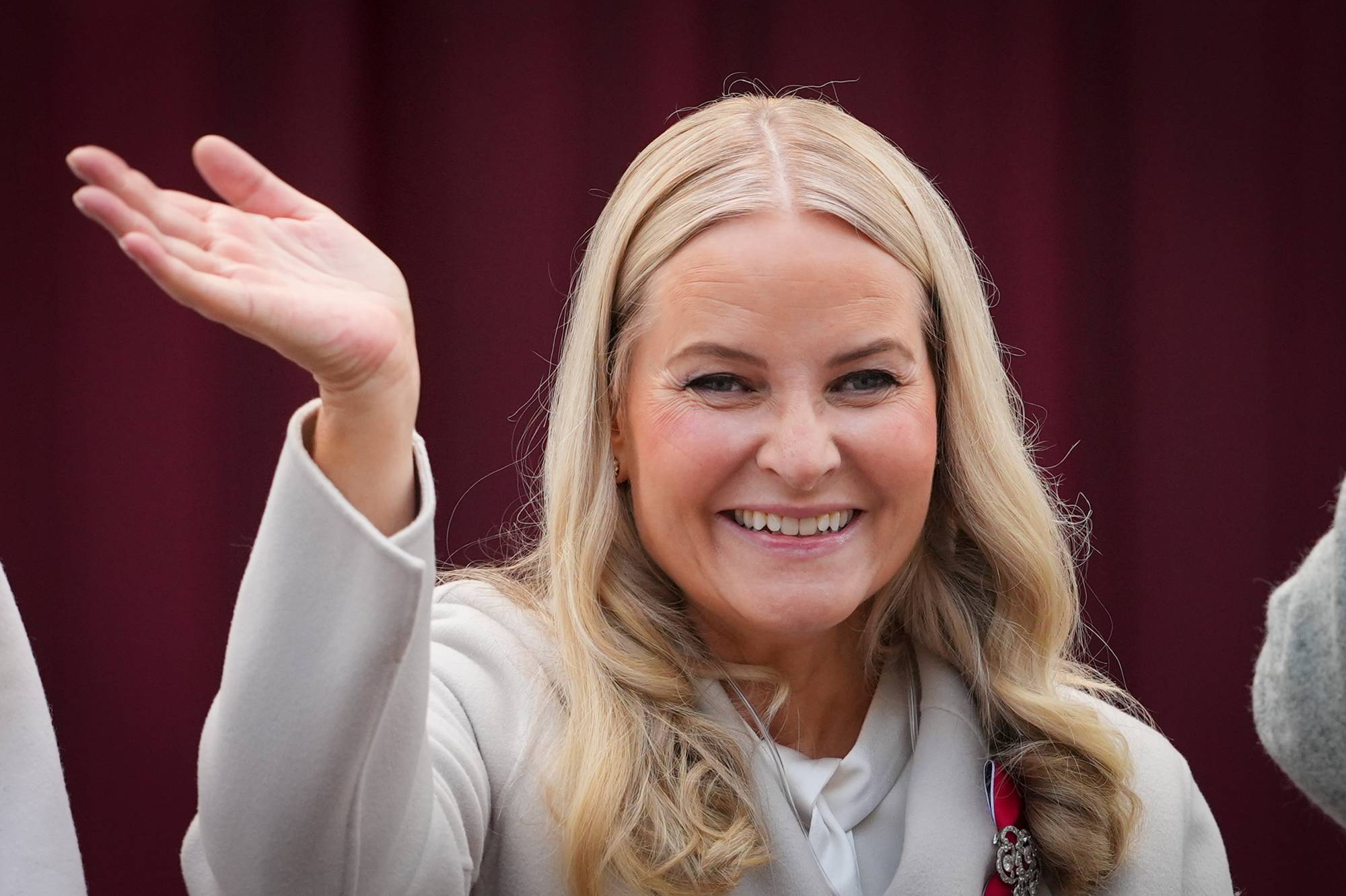 Kronprinsesse Mette-Marit smiler og vinker til barnetoget på Skaugum på 17. mai 2026
