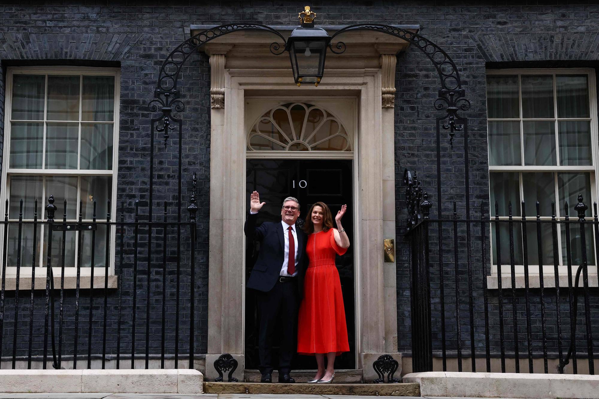 Storbritannias påtroppende statsminister og leder av Arbeiderpartiet, Keir Starmer, og hans kone Victoria, vinker mens de poserer på trappene til Downing Street 10 i London 5. juli 2024, dagen etter at Storbritannia holdt et stortingsvalg