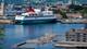 Lise Åserud / NTB Et stort cruiseskip, "Go Nordic Cruiseline", ligger ved kai i Oslo havn. I forgrunnen bader og soler folk seg på en flytende badeplattform. Bygninger og en bybakgrunn sees i det fjerne. (Bildebeskrivelsen er laget av en KI-tjeneste)