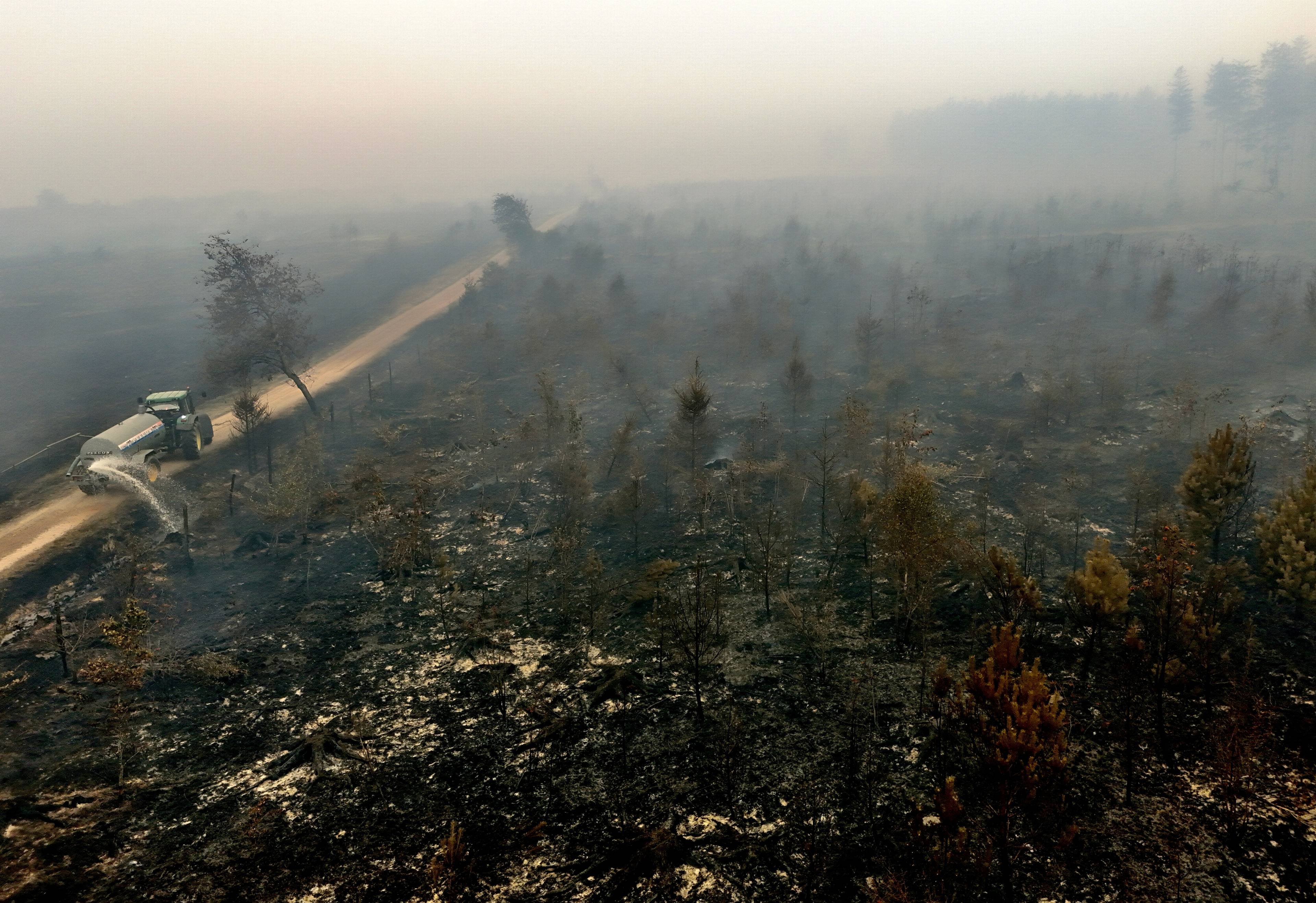 Tankbil tømmer vann i nedbrent skog