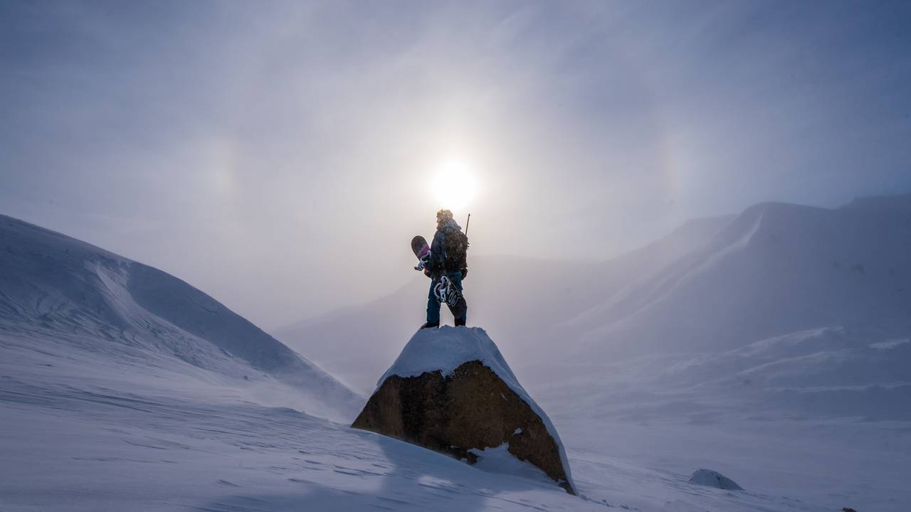 Stian Aadland med snowboard foran solen