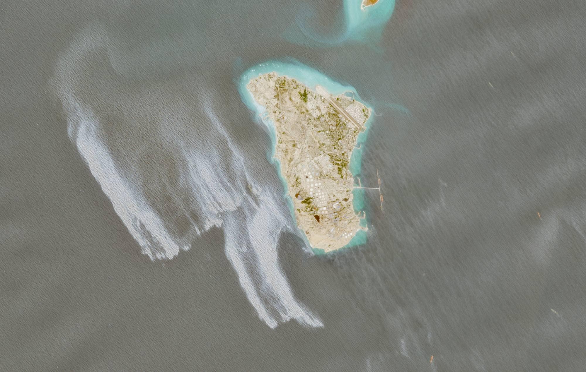 Satelittbilde av øy med hvite områder i havet ved siden 