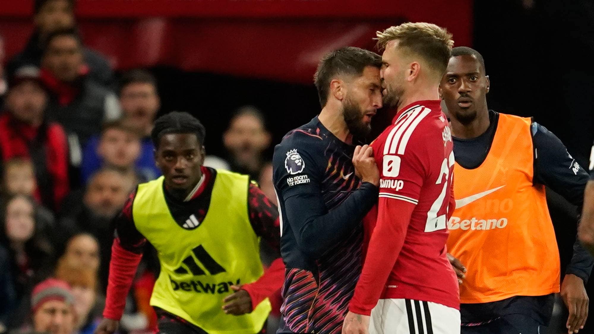 To fotballspillere står ansikt til ansikt i en konfrontasjon på banen. (Bildebeskrivelsen er laget av en KI-tjeneste)