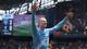 Phil Noble / REUTERS,NTB Fotballspilleren Erling Braut Haaland jubler med armene i været. Han er iført en lyseblå Manchester City-drakt. I bakgrunnen vises en resultattavle med stillingen 3-0. Rundt er det tilskuere på en fotballarena. (Bildebeskrivelsen er laget av en KI-tjeneste)
