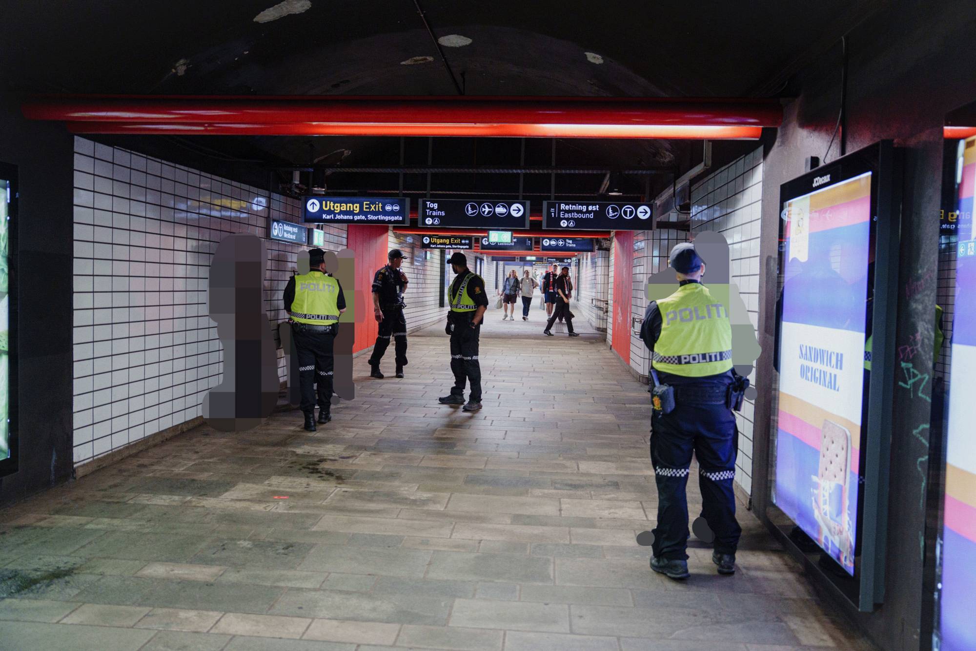 Politiet står på Nationaltheateret stasjon og snakker med de innvolverte i en slåsskamp. De innvolverte er sladdet. 