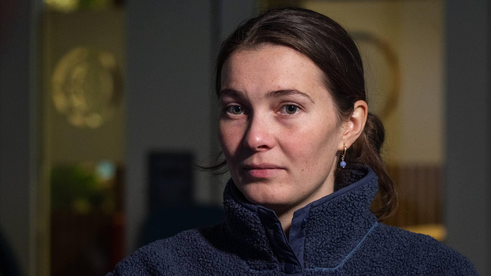 Portrett av en kvinne med mørkt hår, kledd i en mørkeblå fleecejakke. (Bildebeskrivelsen er laget av en KI-tjeneste)