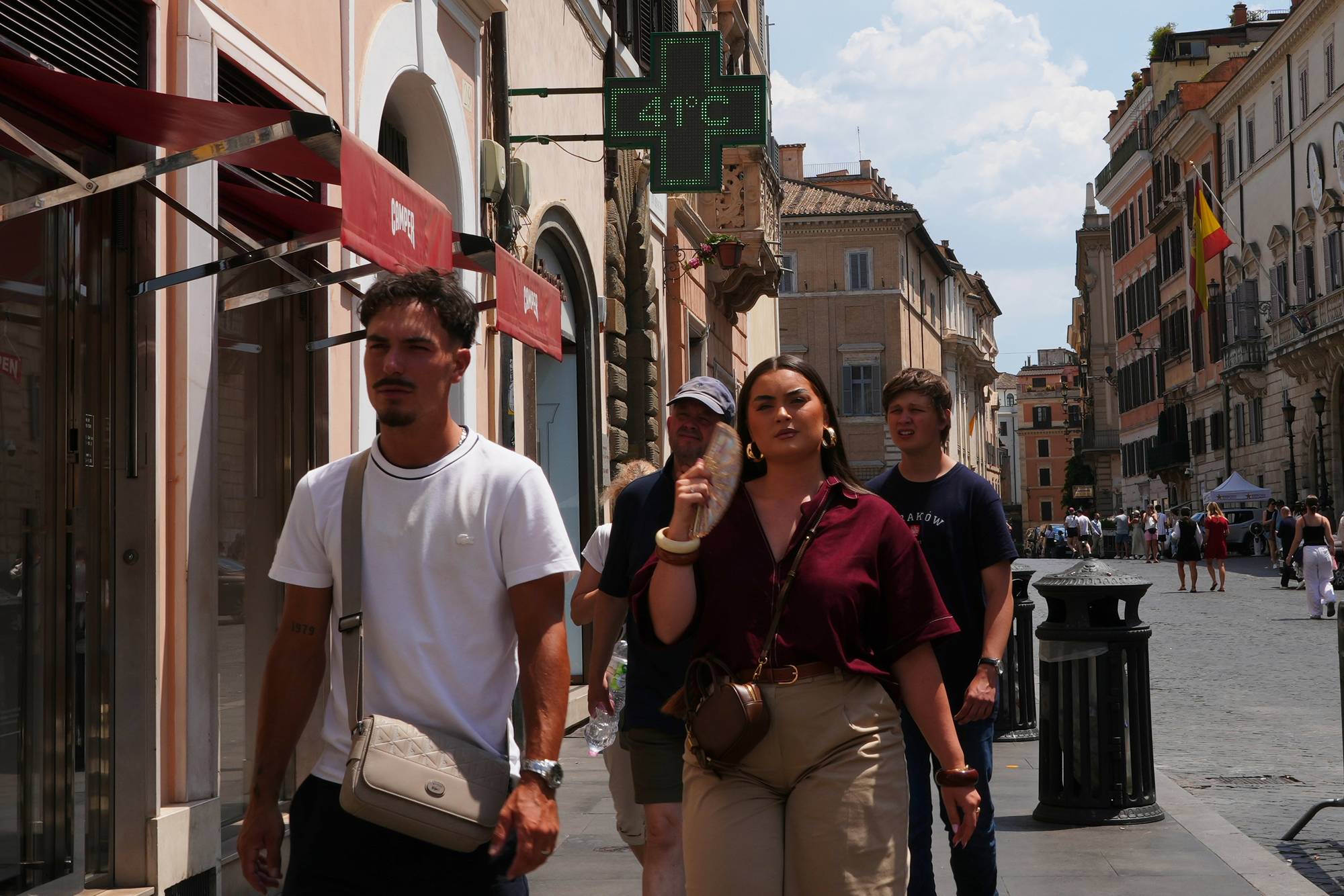 Folk i varme gater i Roma
