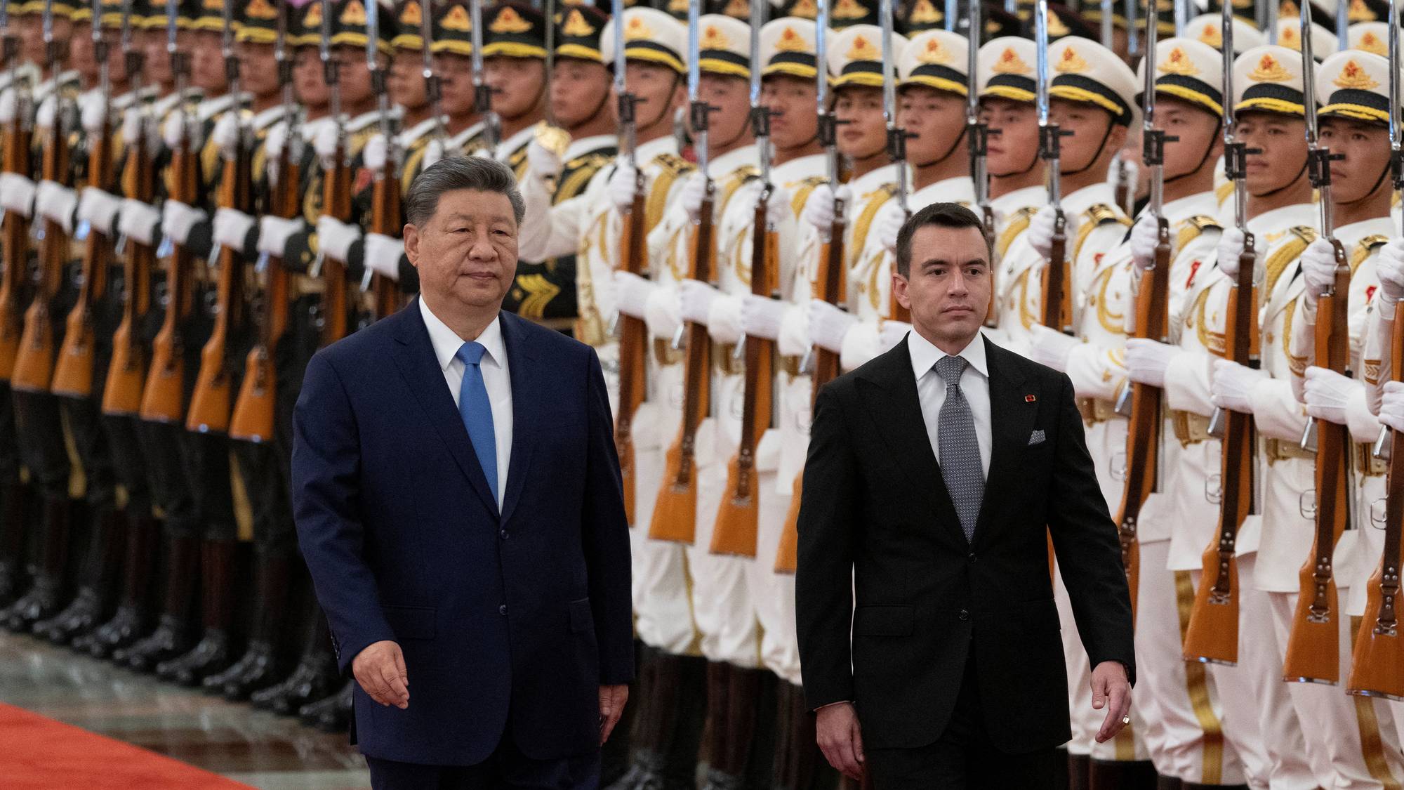 Kinas president Xi Jinping og Ecuadors president Daniel Noboa går foran en æresvakt i uniformer med geværer. 