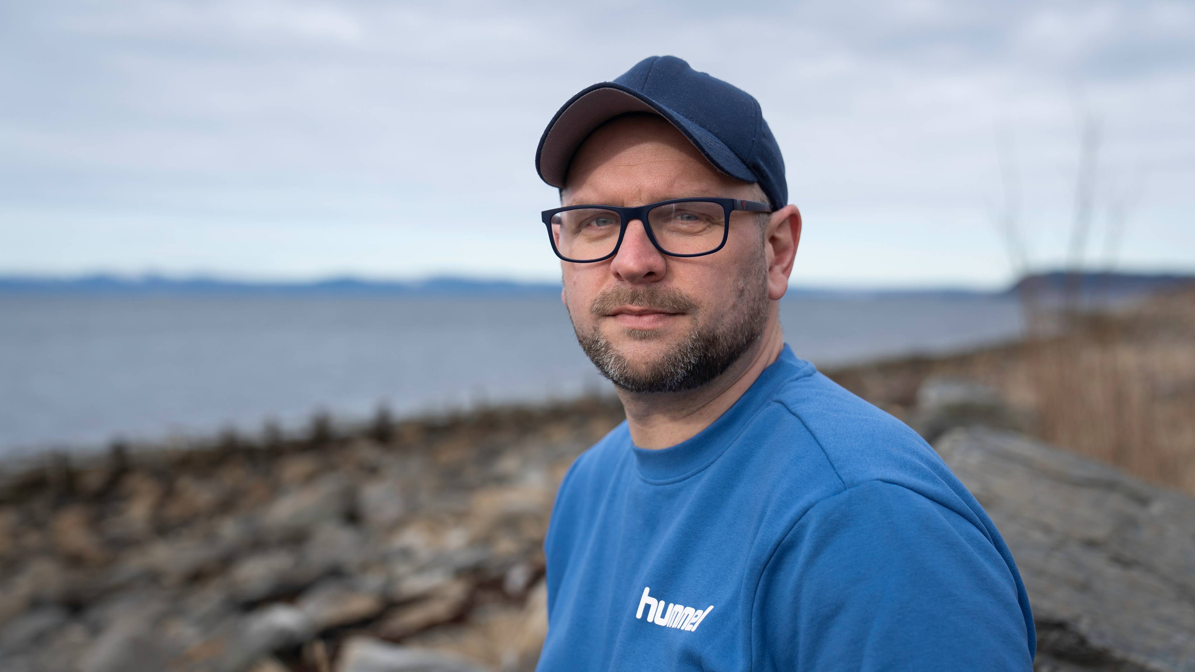 Mann med caps ser i kamera