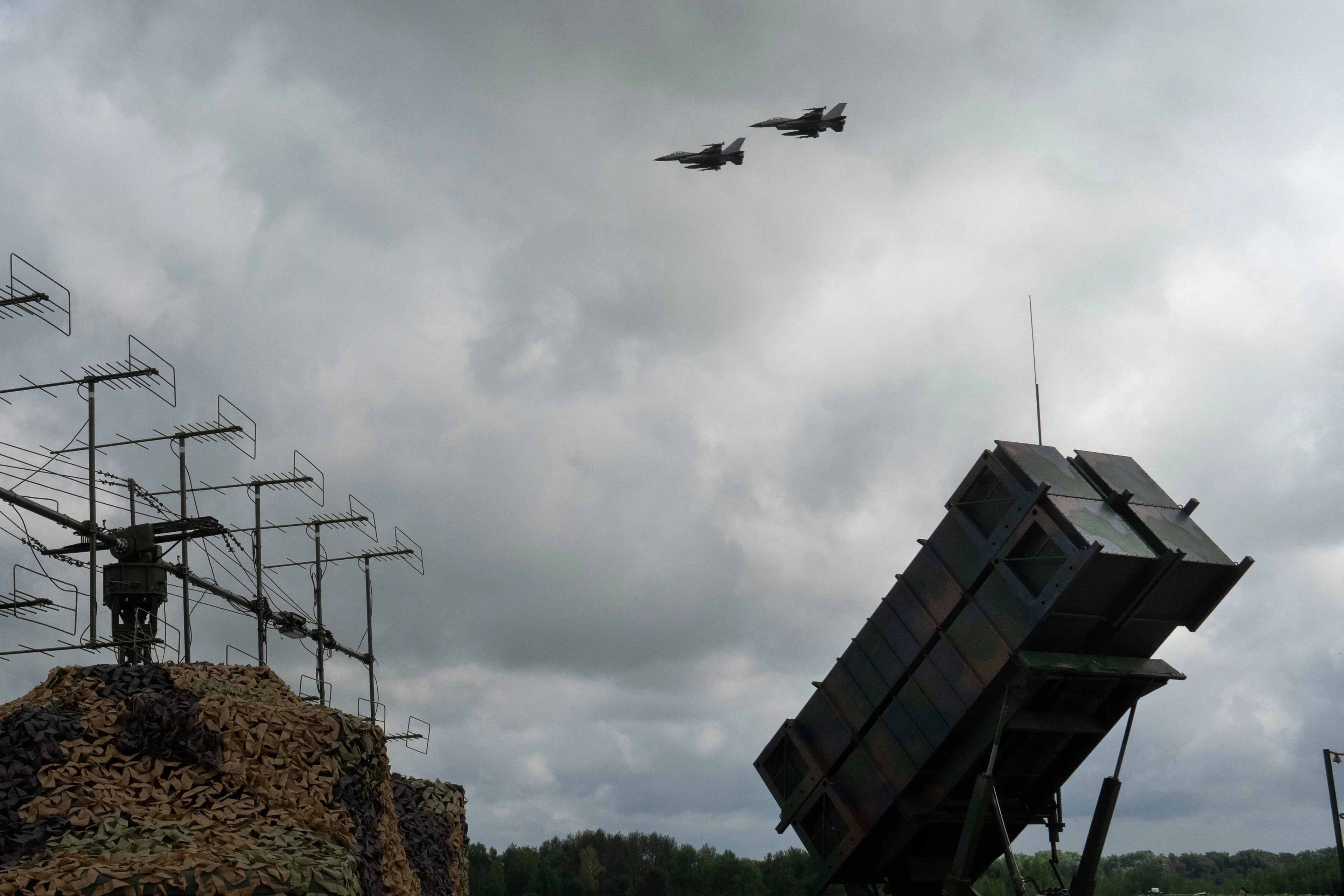 To jagerfly flyr over et missilforsvarssystem