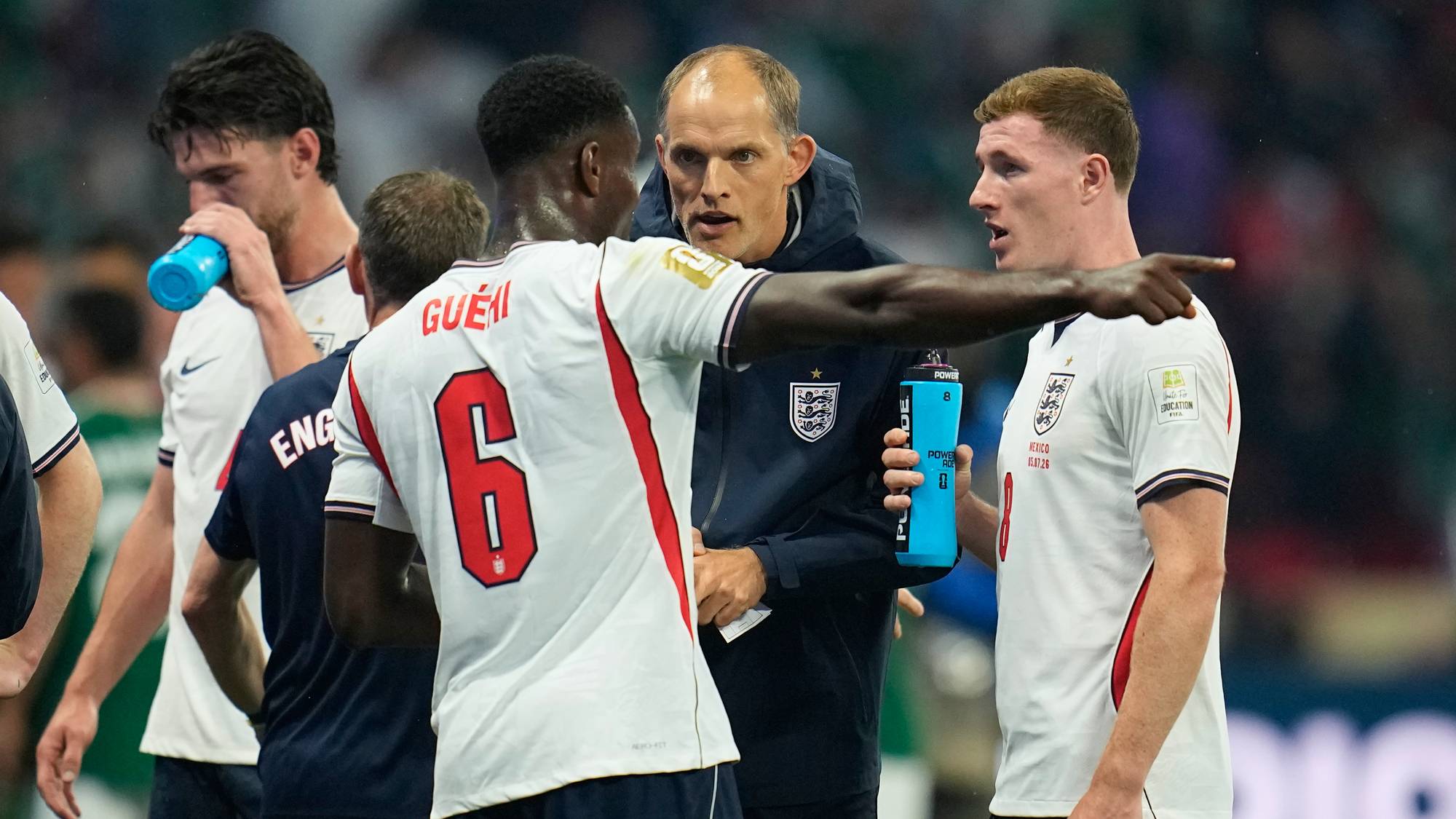 Trener Thomas Tuchel gir instrukser til engelske landslagsspillere på banen under en kamp. (Bildebeskrivelsen er laget av en KI-tjeneste)