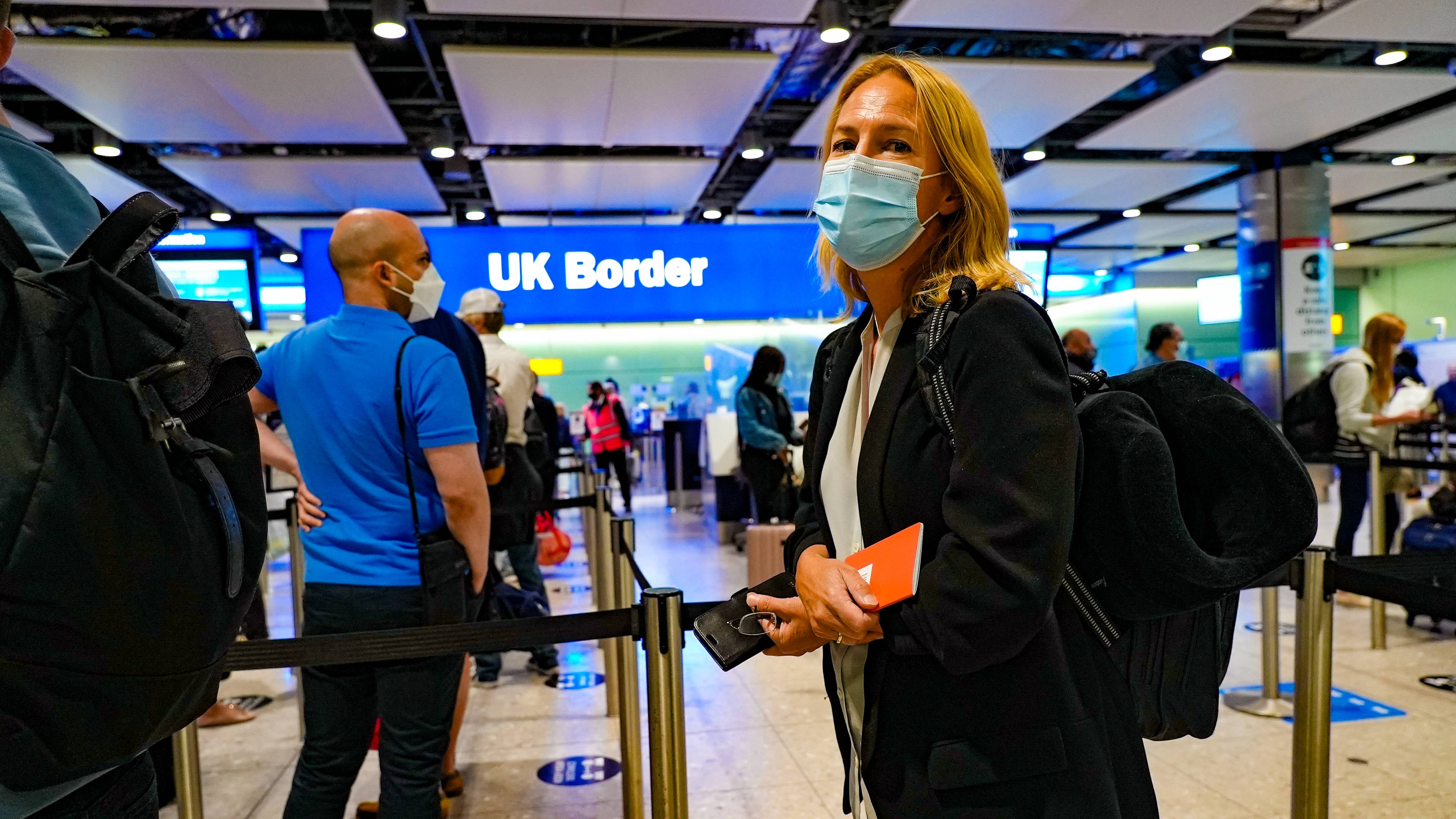 Reporter med munnbind på vei gjennom passkontrollen