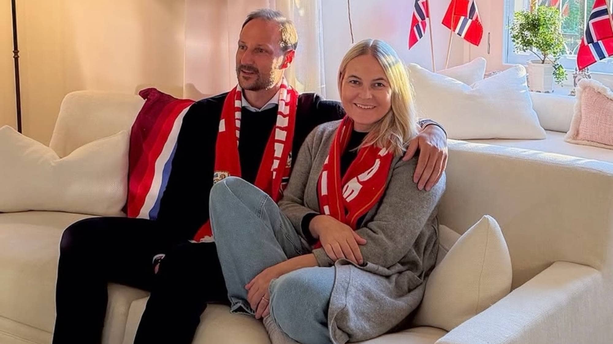 Kornprinsparet sitt i ein sofa med norske supportereffektar