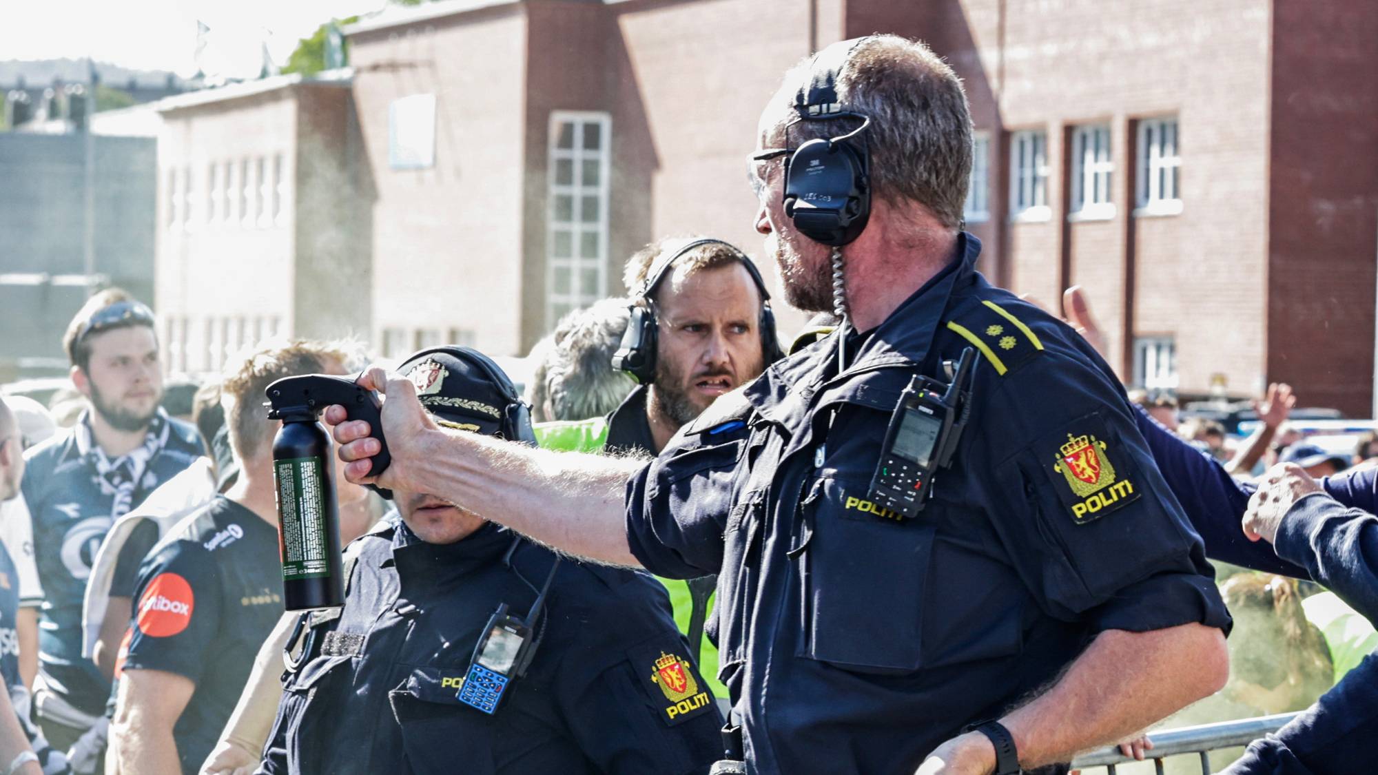 politiet med tåregass som sprayes mot mennesker