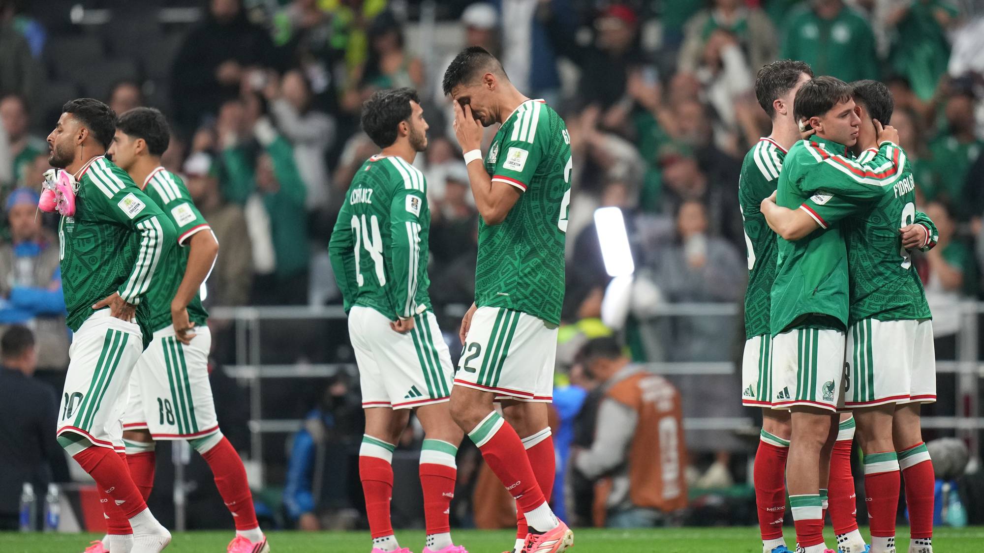 Skuffede fotballspillere fra Mexico på banen etter en kamp. Flere spillere gråter. (Bildebeskrivelsen er laget av en KI-tjeneste)
