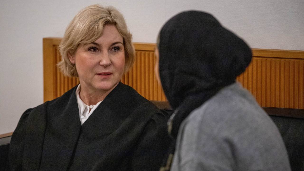 Bistandsadvikaten og lillesøster sitter på en benk, ser på hverandre.
