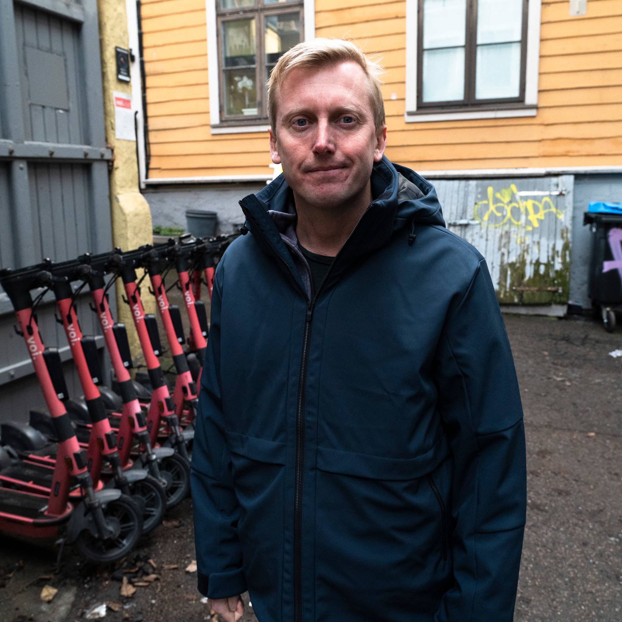 Øystein Sundelin står foran mange elsparkesykler 