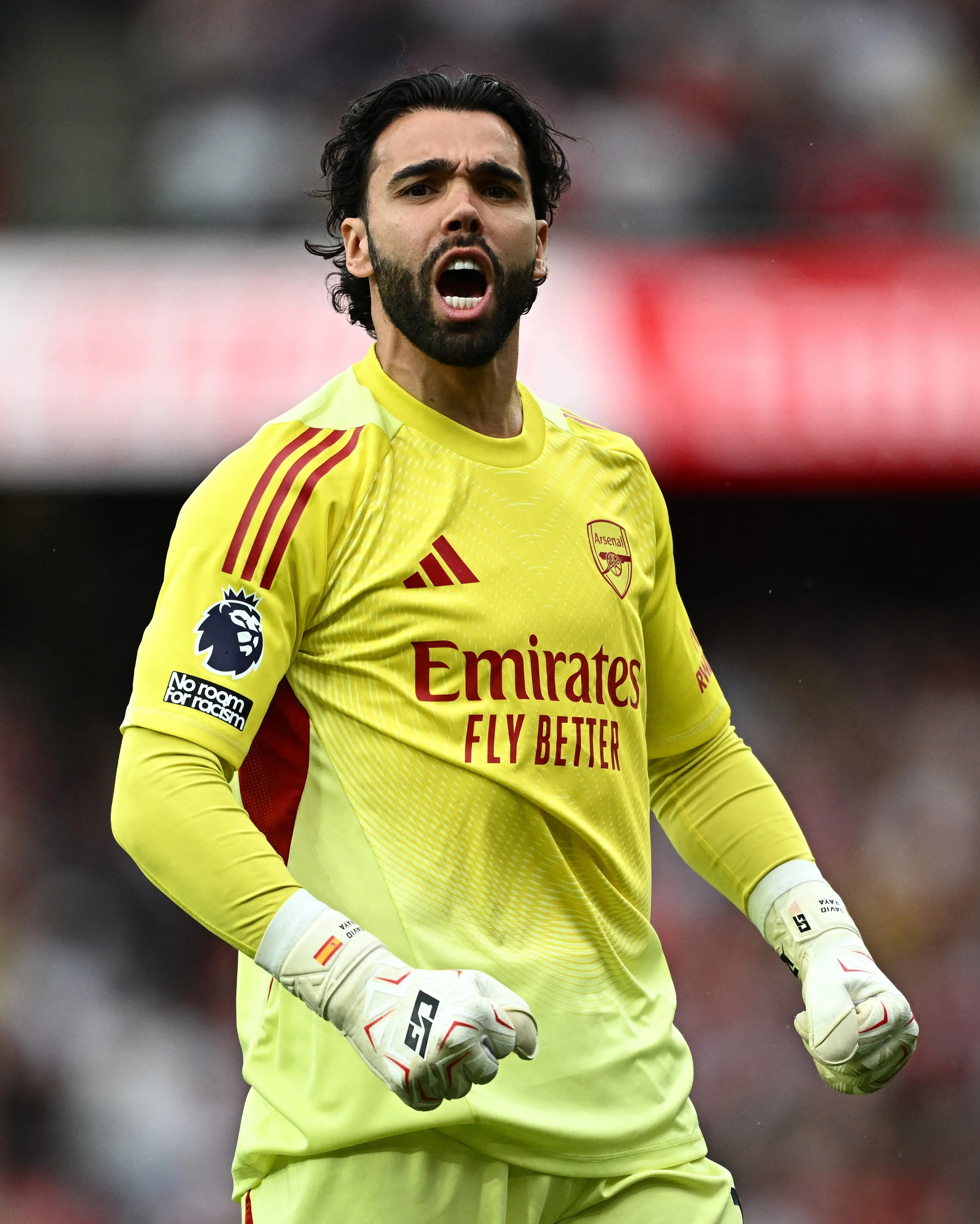 Arsenal-keeper David Raya jubler på banen i gul drakt. (Bildebeskrivelsen er laget av en KI-tjeneste)