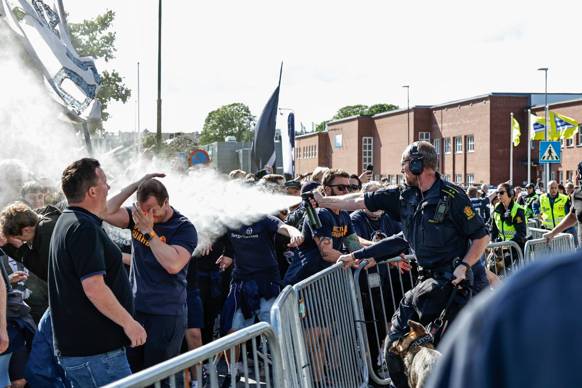 politiet med tåregass som sprayes mot mennesker