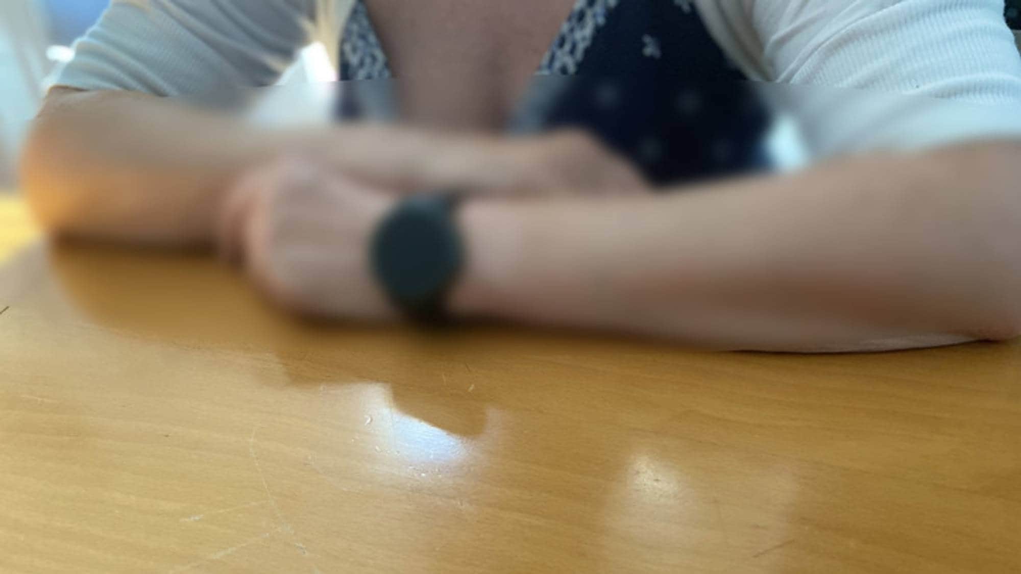På bildet ser man en person som lener armene på et bord.