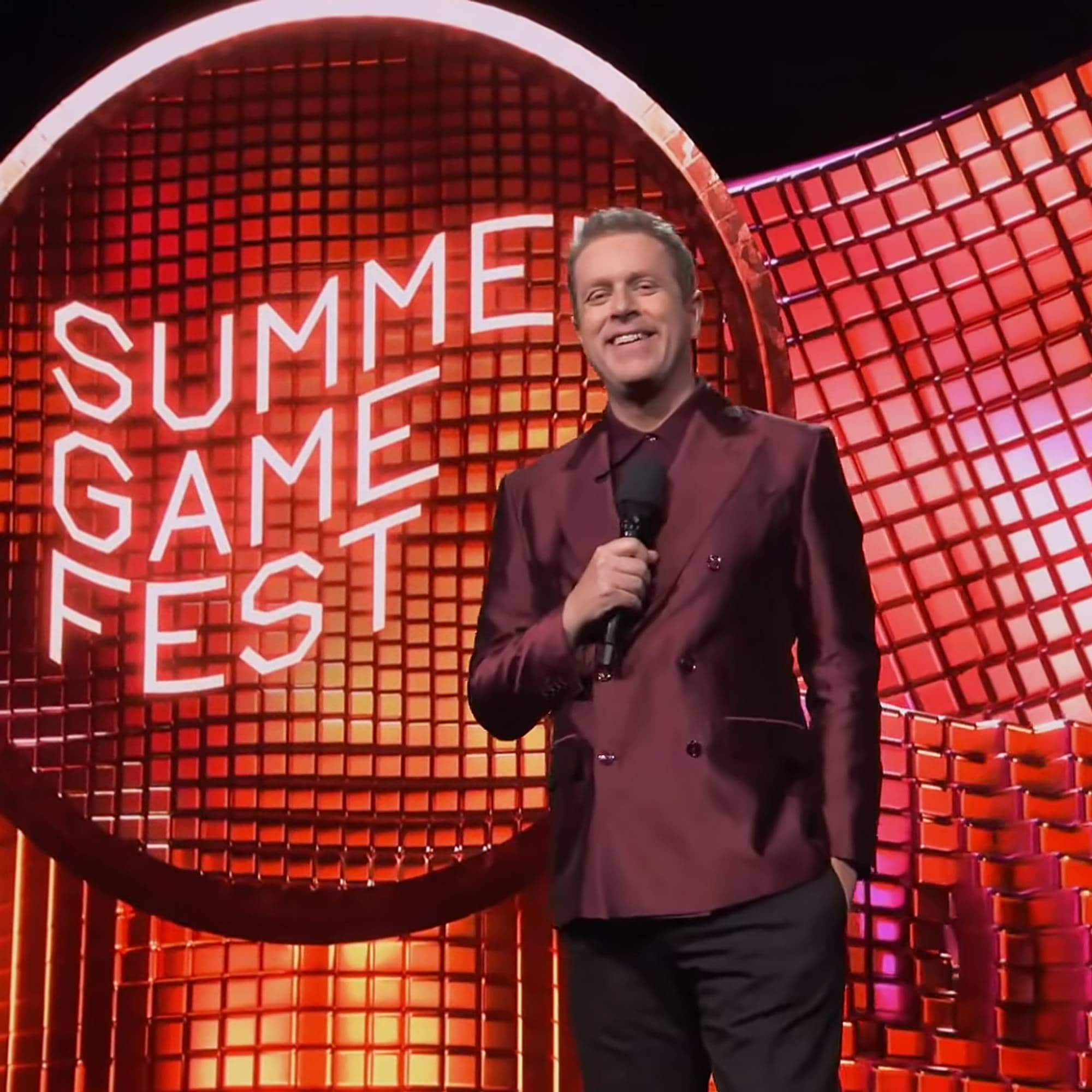 En mann på en scene med mikrofon, foran en skjerm som sier Summer Game Fest