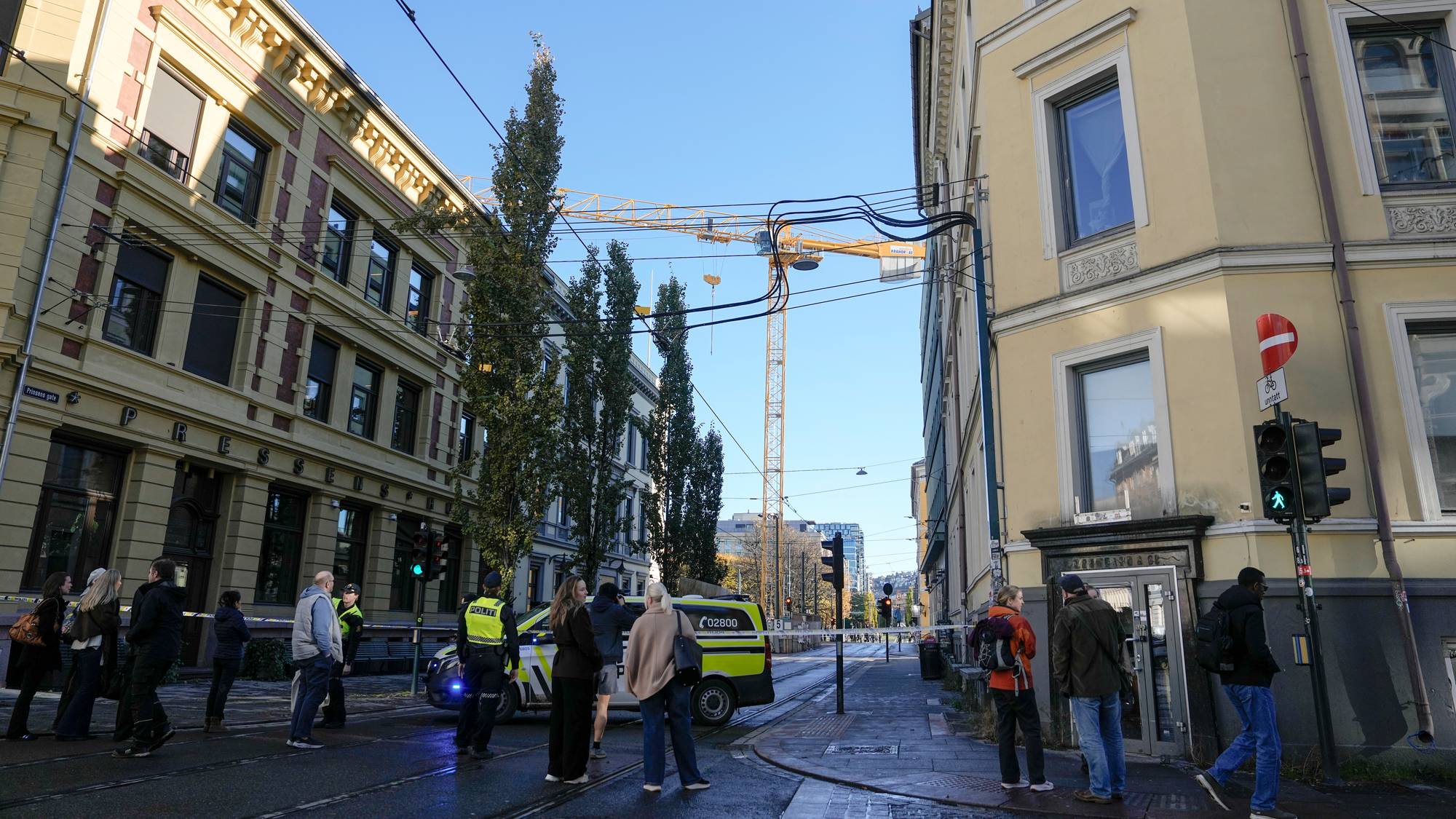 Politi ved en byggeplass i en gate med bygårder. En byggekran er synlig i bakgrunnen. (Bildebeskrivelsen er laget av en KI-tjeneste)