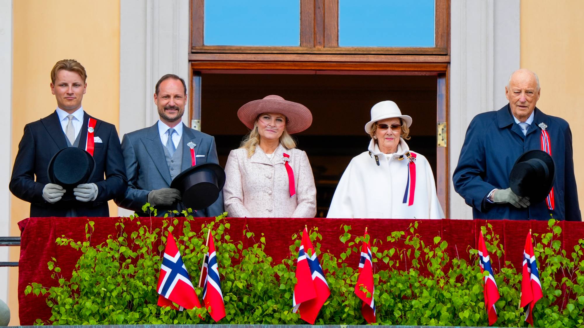 Kongefamilien hilser barnetoget i Oslo fra Slottsbalkongen på 17. mai 2026