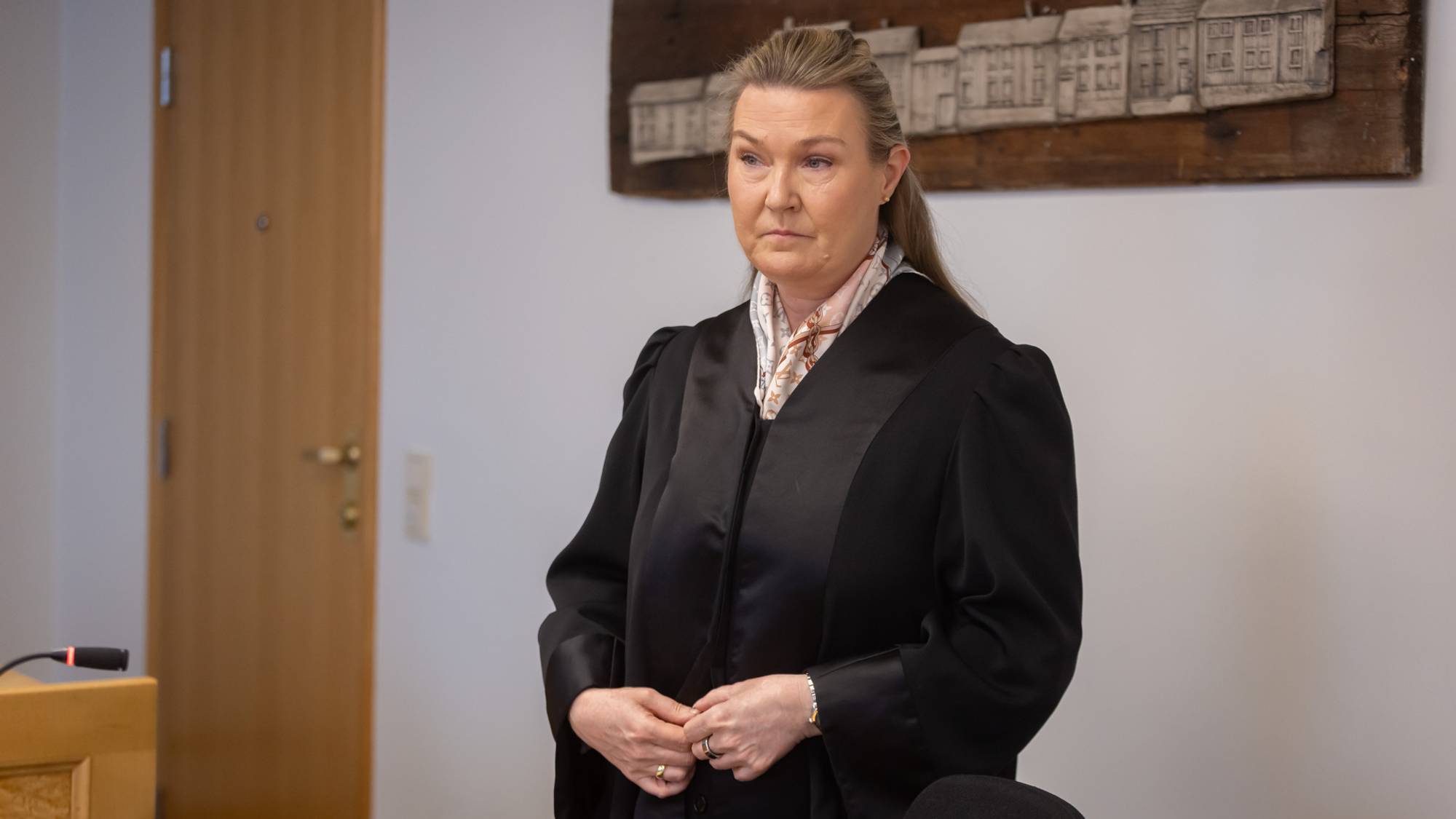 Forsvarsadvokat Siv Aida Rui står i en rettssal i Trøndelag tingrett. Hun har tatt på seg kappen og er i ferd med å kneppe den sammen. Hun kikker bestemt foran seg