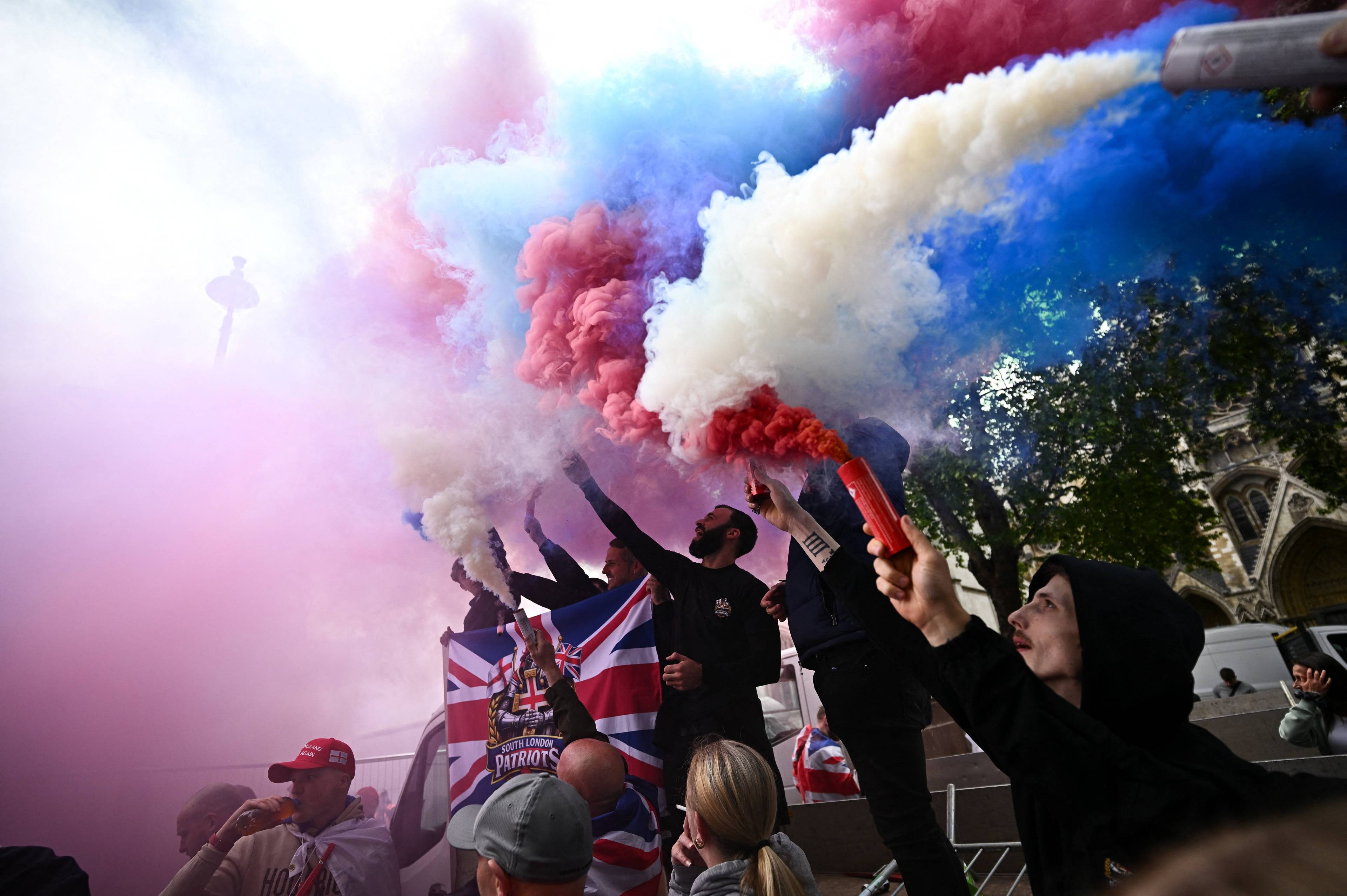 Folk holder fargede røykbomber. Noen har britiske flagg som det står "South London Patriots på)