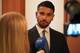 Mathias Revheim-Rafaelsen / NRK En mann i dress og slips blir intervjuet av en person som holder en mikrofon med NRK-logo. Bak mannen er det en brun vegg med vertikale striper. En del av et kamera ses til høyre i bildet. (Bildebeskrivelsen er laget av en KI-tjeneste)