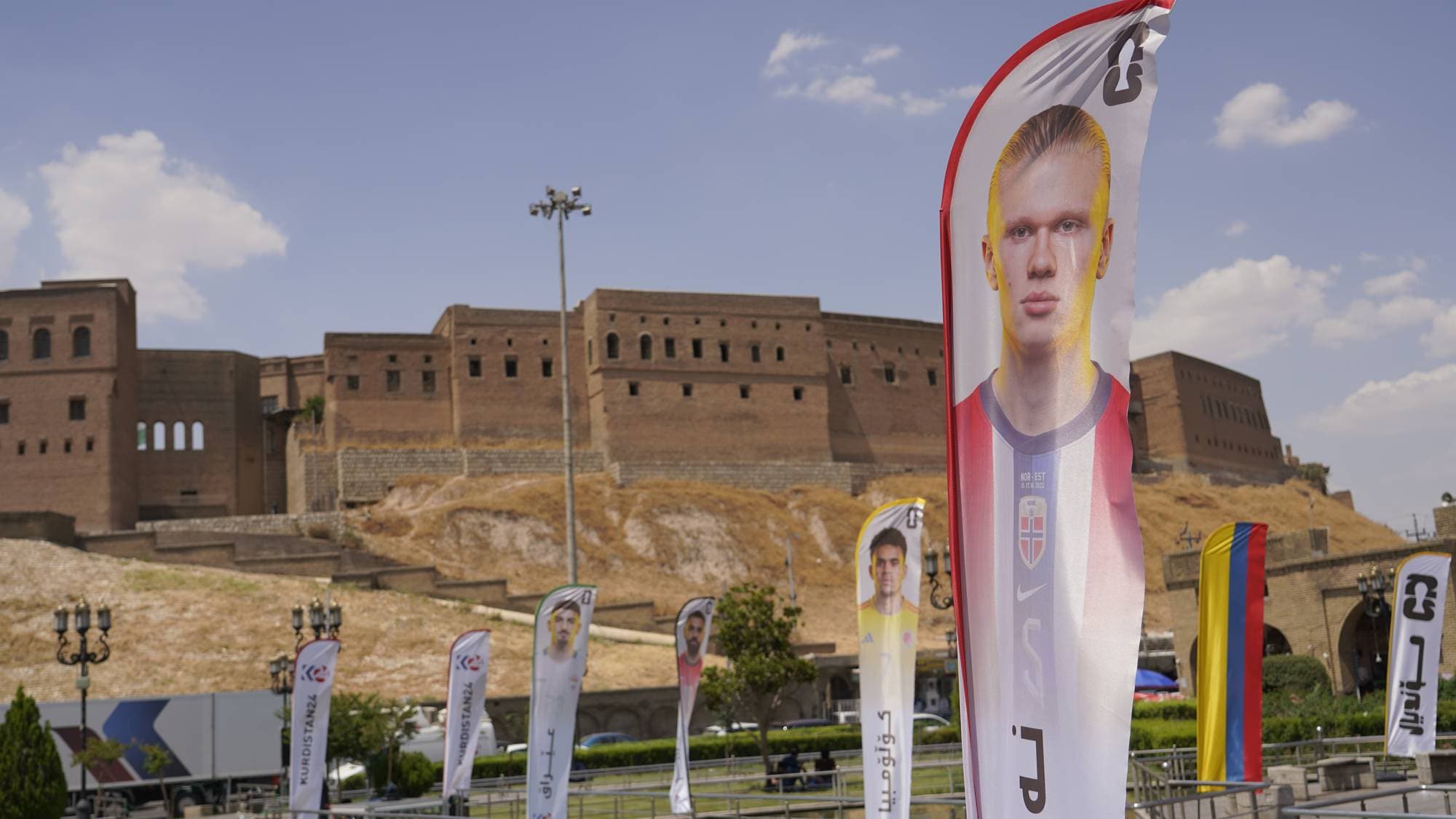 Fotballbanner med Haaland foran borg i Erbil.