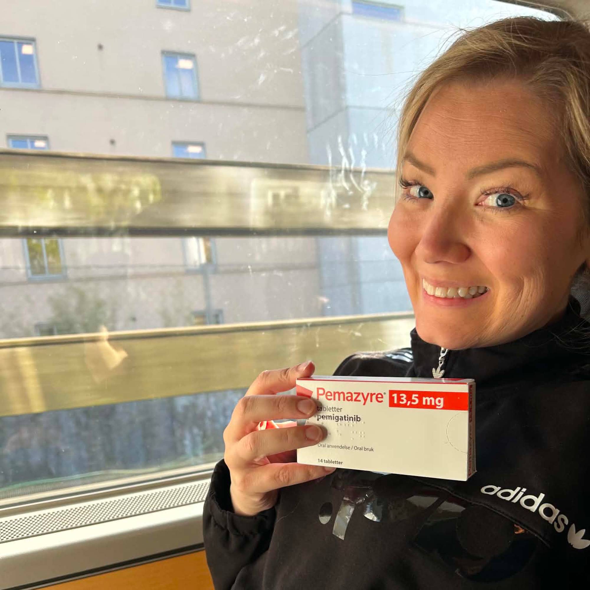 Kvinne som holder opp en medisinpakke. 