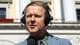 NTB / NTB Mann med hodetelefoner og mikrofon foran Det kongelige slott. (Bildebeskrivelsen er laget av en KI-tjeneste)