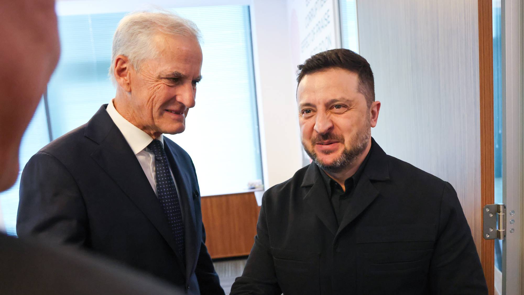 Jonas Gahr Støre hilser på Ukrainas president Volodymyr Zelenskyj i et kontorlokale. 