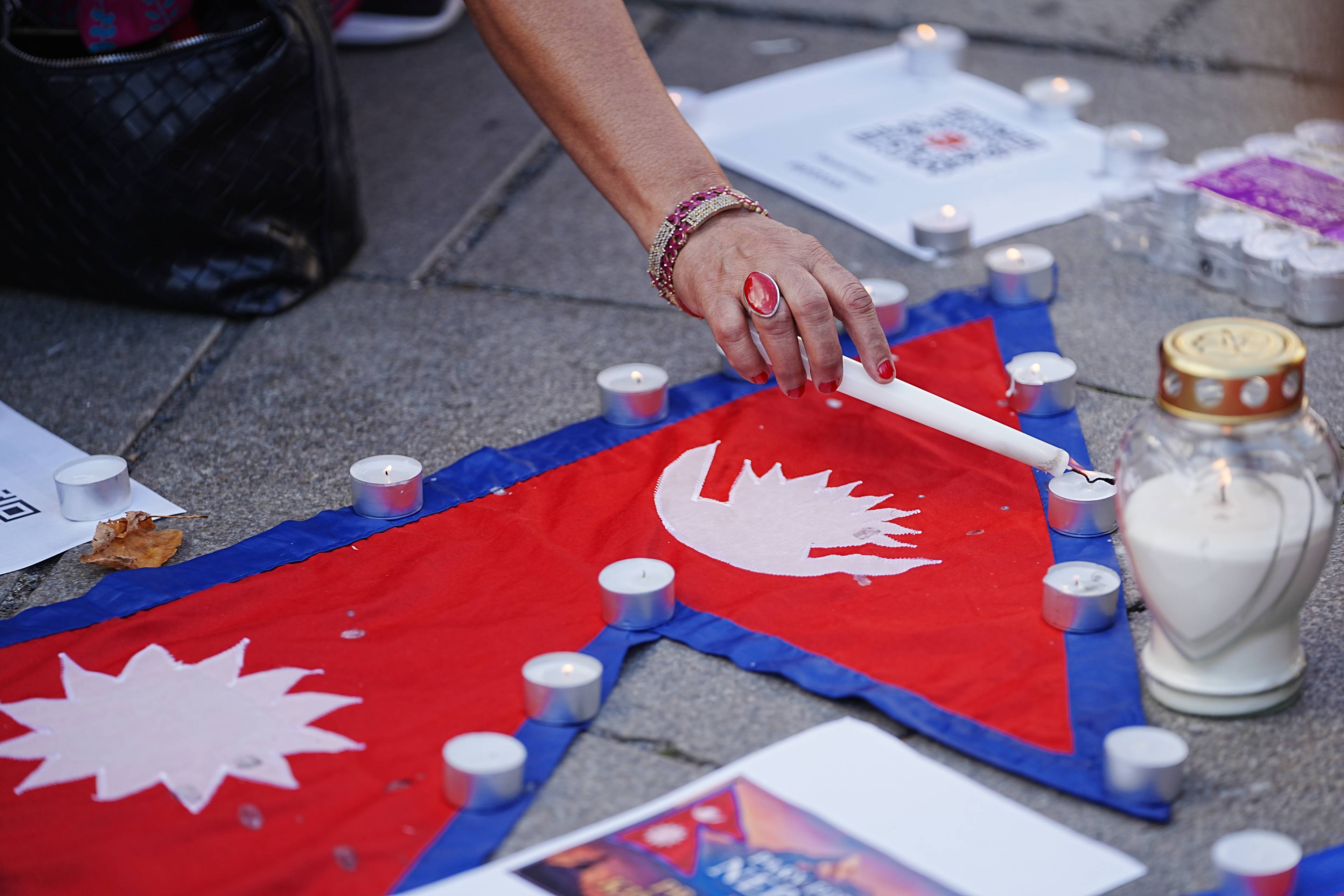 Diverse bilete av nepalesere som tenner lys, legger blomster og held opp plakatar ifbm flaumkatastrofen i Nepal.