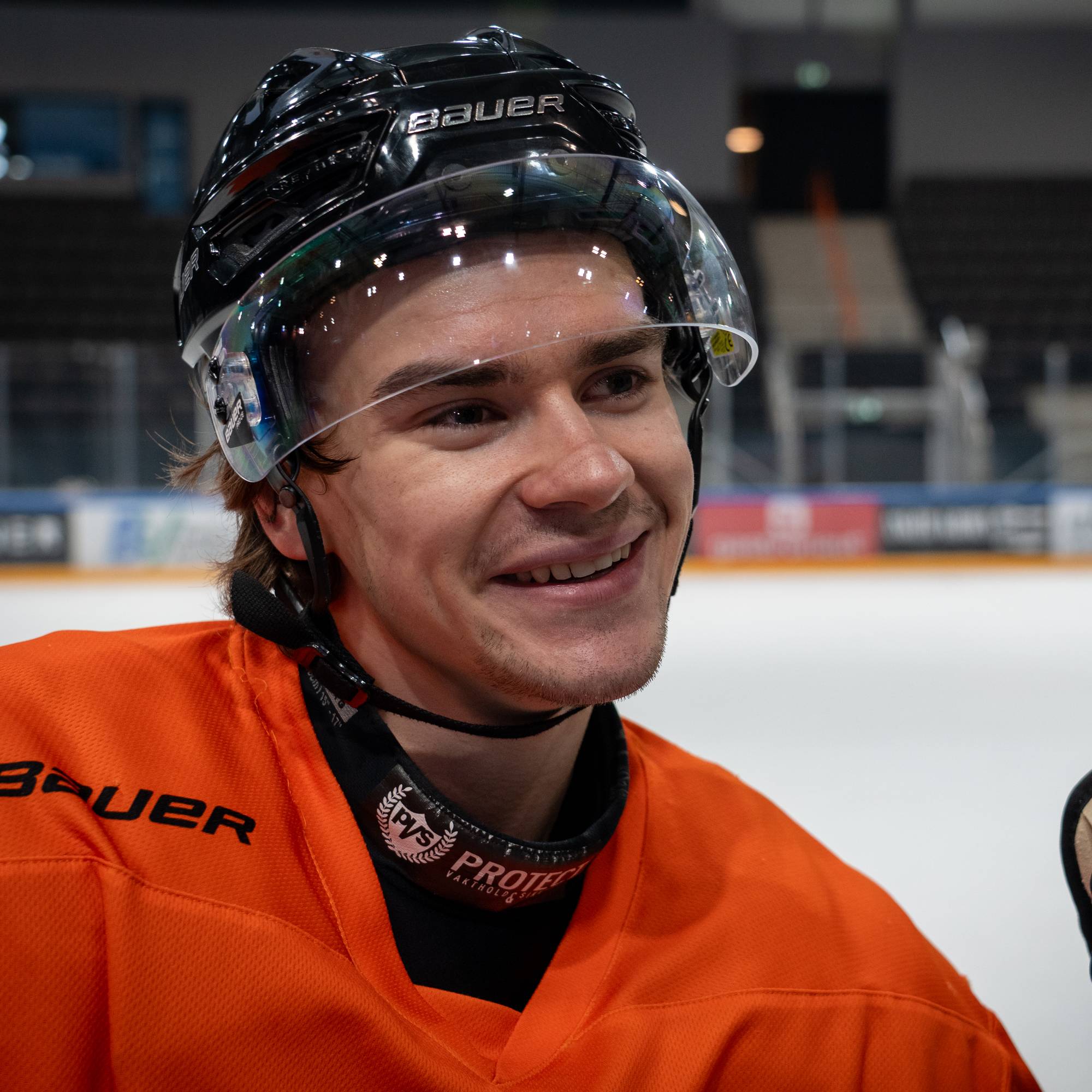 en mann i hockeyutstyr smiler