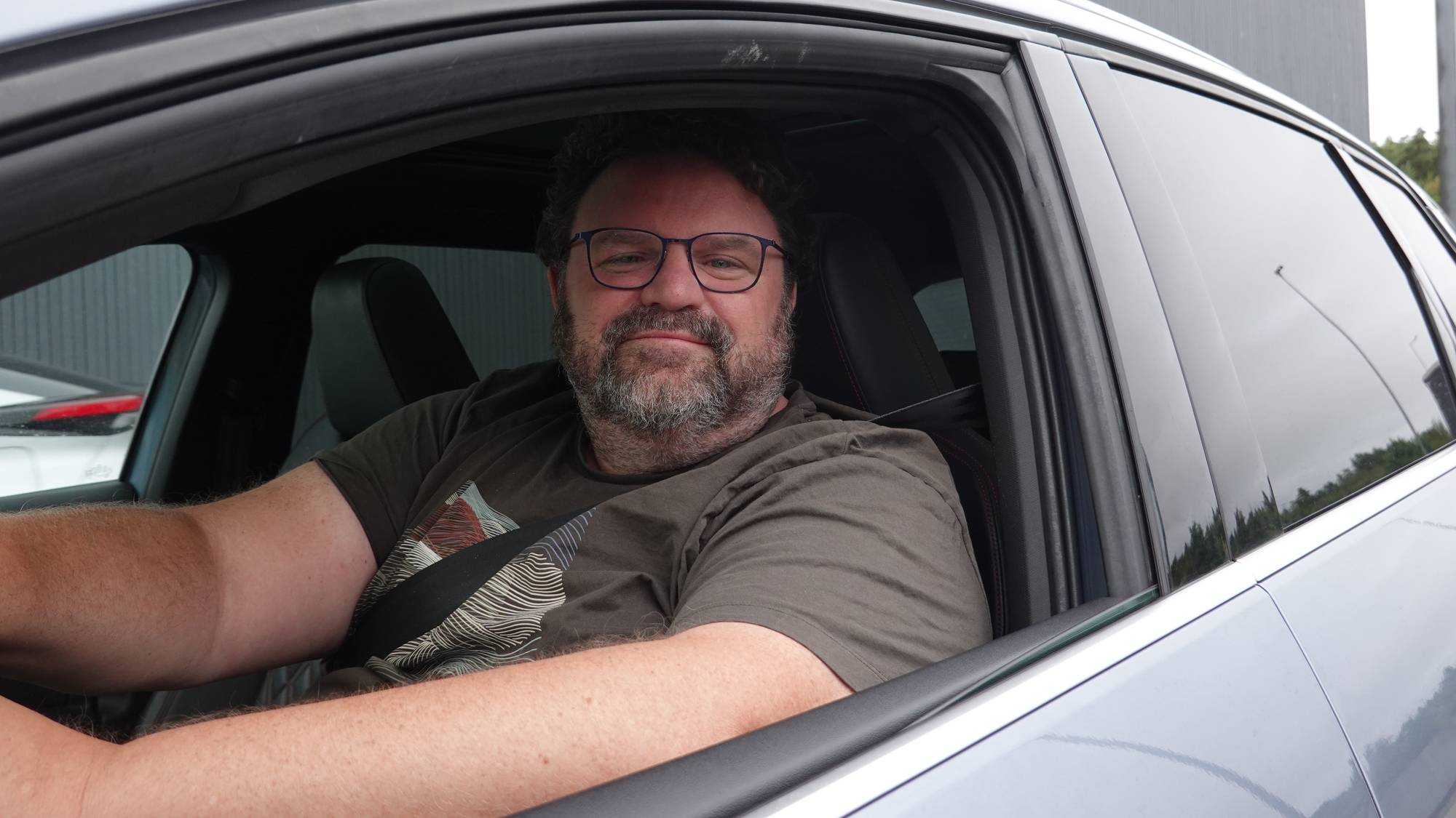 Svenske Robert Qvist krysset grensa på Svinesund i morges. Sitter i bilen på førerplass og smiler til fotografen.