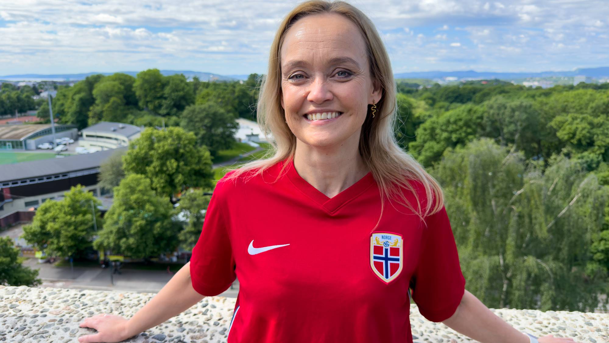 En kvinne i rød Norge-T-skjorte (Bildebeskrivelsen er laget av en KI-tjeneste)