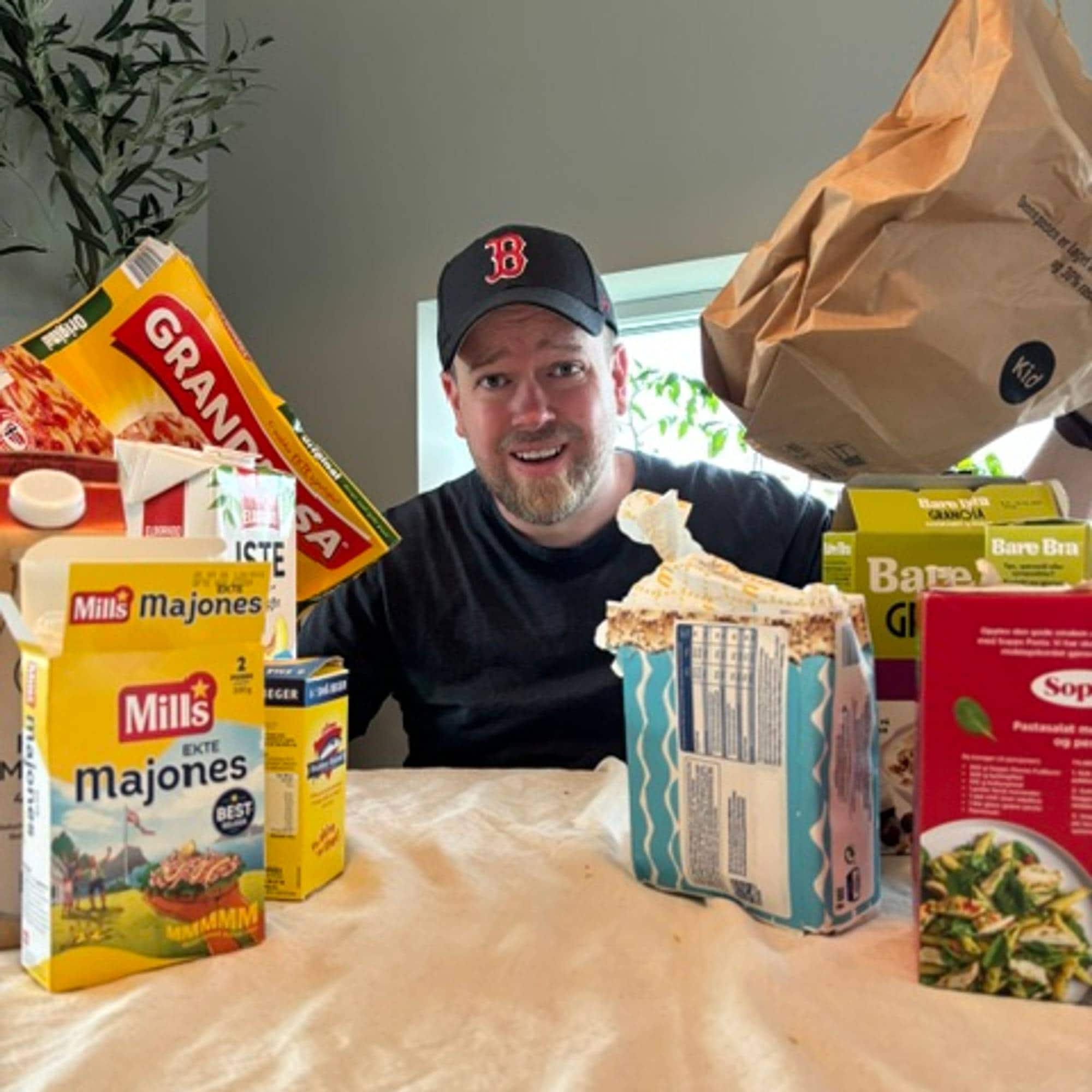 En person som står foran en pizzaeske (Bildebeskrivelsen er laget av en KI-tjeneste)