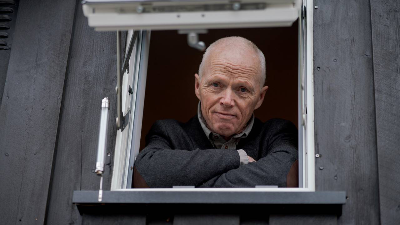 Robert Mood ser i kamera fra et lite vindu.