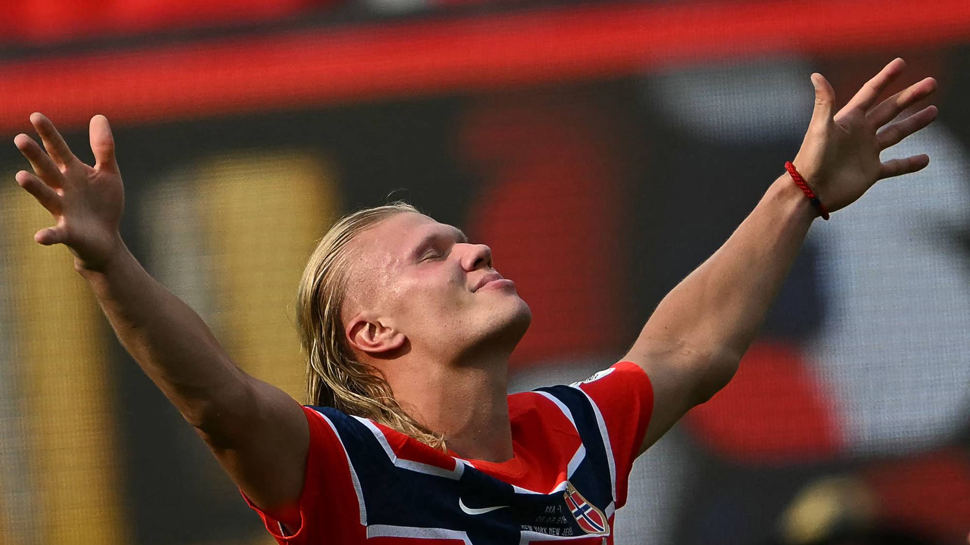 Erling Braut Haaland feirer med armene hevet i en norsk landslagsdrakt. (Bildebeskrivelsen er laget av en KI-tjeneste)