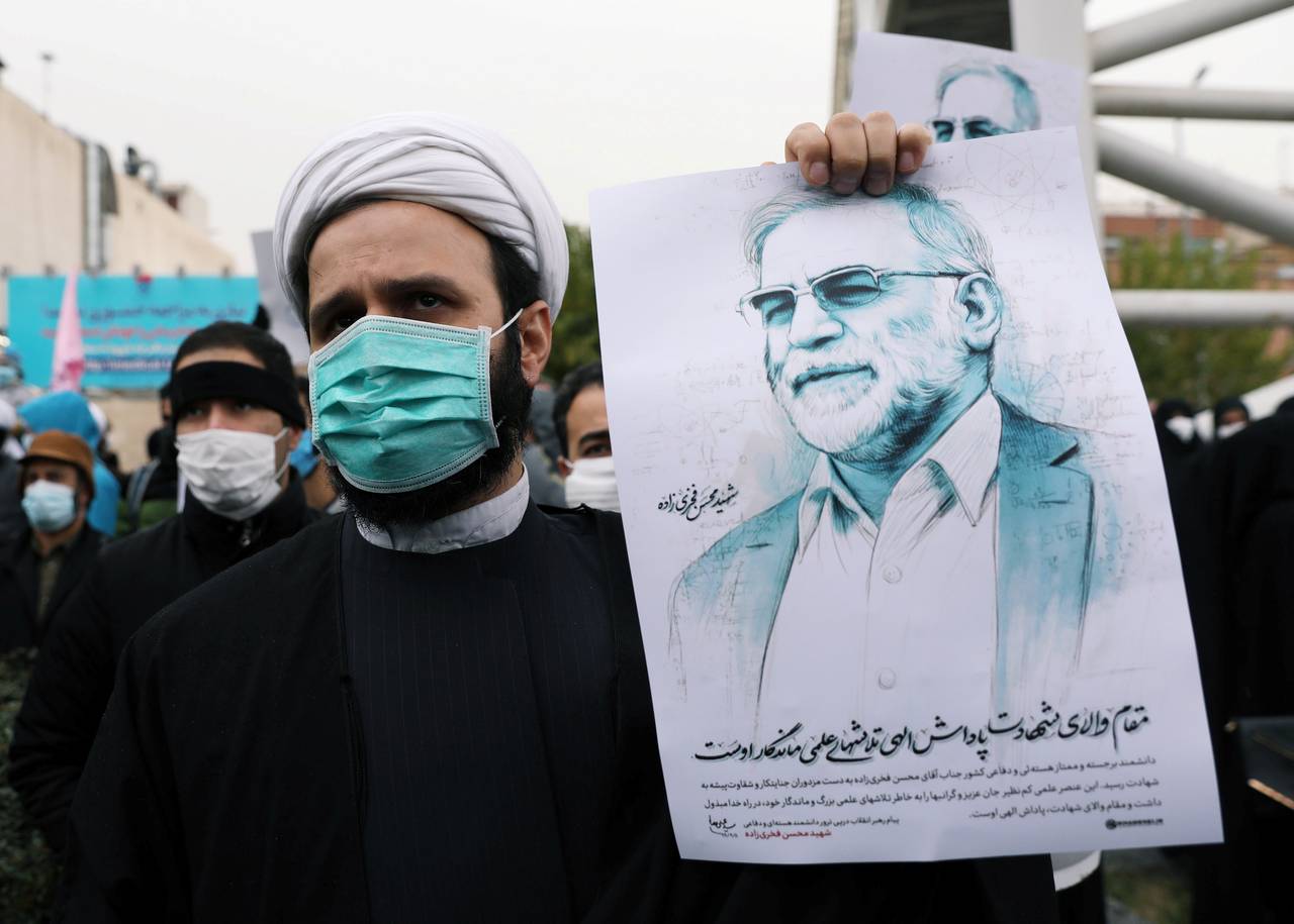 En demonstrant holder opp et bilde av atomforsker Mohsen Fakhrizadeh som ble drept i et attentat fredag. 