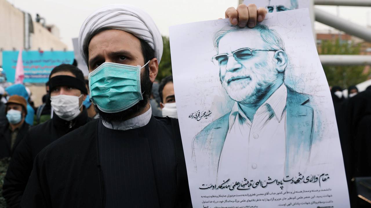 A protester holds up a photo of nuclear scientist Mohsen Fakhrizadeh, who was killed in an assassination attempt on Friday. 