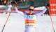 BARBARA GINDL / AFP / NTB En utøver feirer seieren i en langrennskonkurranse. Personen er kledd i konkurranseutstyr med sponsormerker. Bakgrunnen viser en skiarena med tilskuere og snødekte løyper. Offisielt banner er synlig i området, med reklametekst. (Bildebeskrivelsen er laget av en KI-tjeneste)